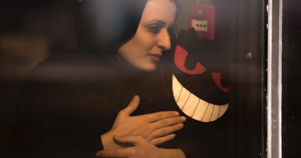 woman holding creepy smiling toy