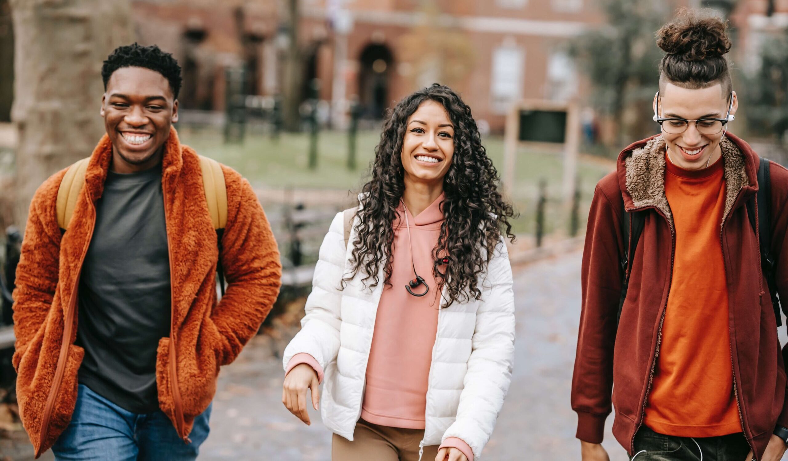 three friends walking along laughing