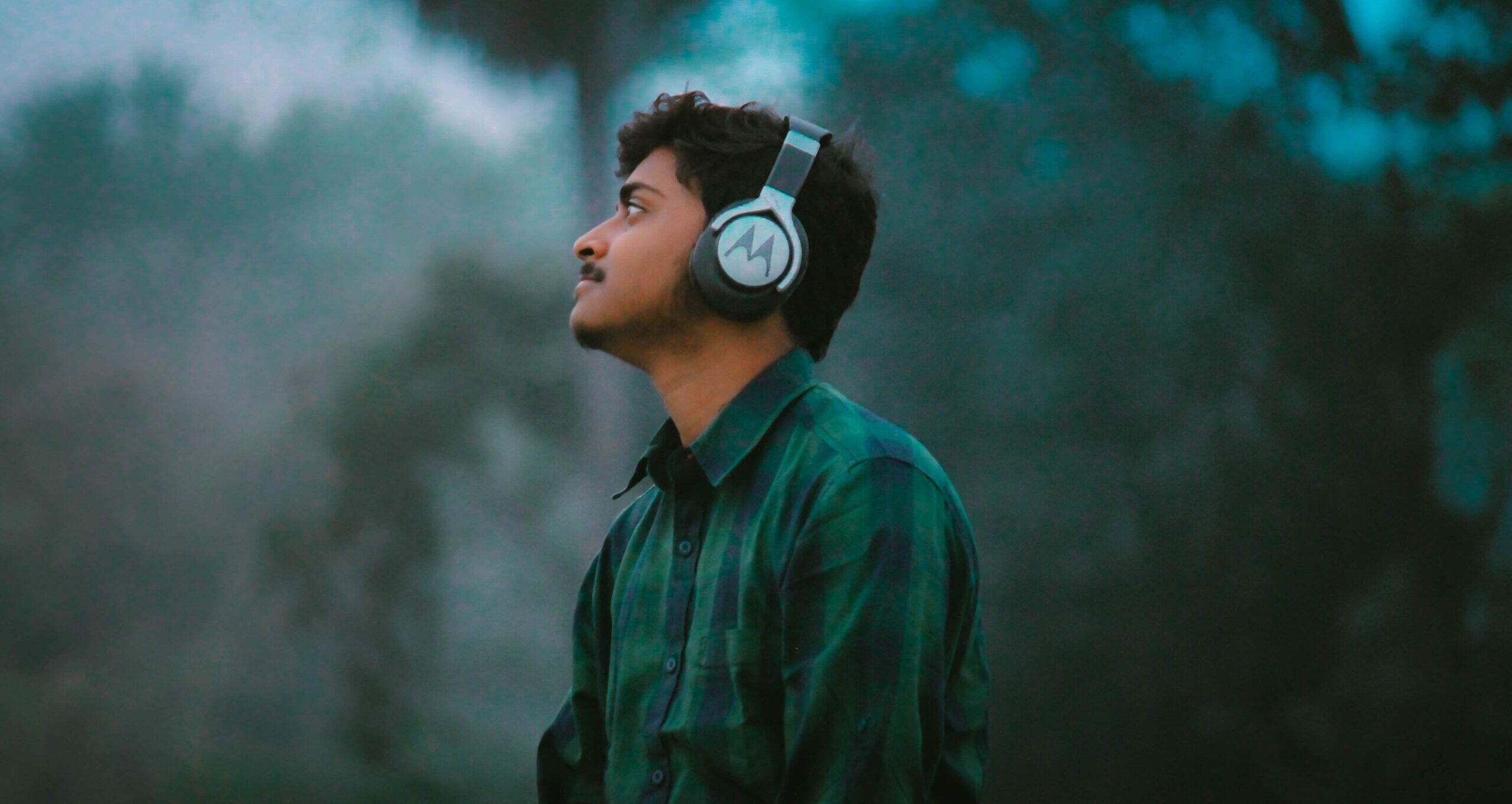 Man wearing headphones surrounded by trees