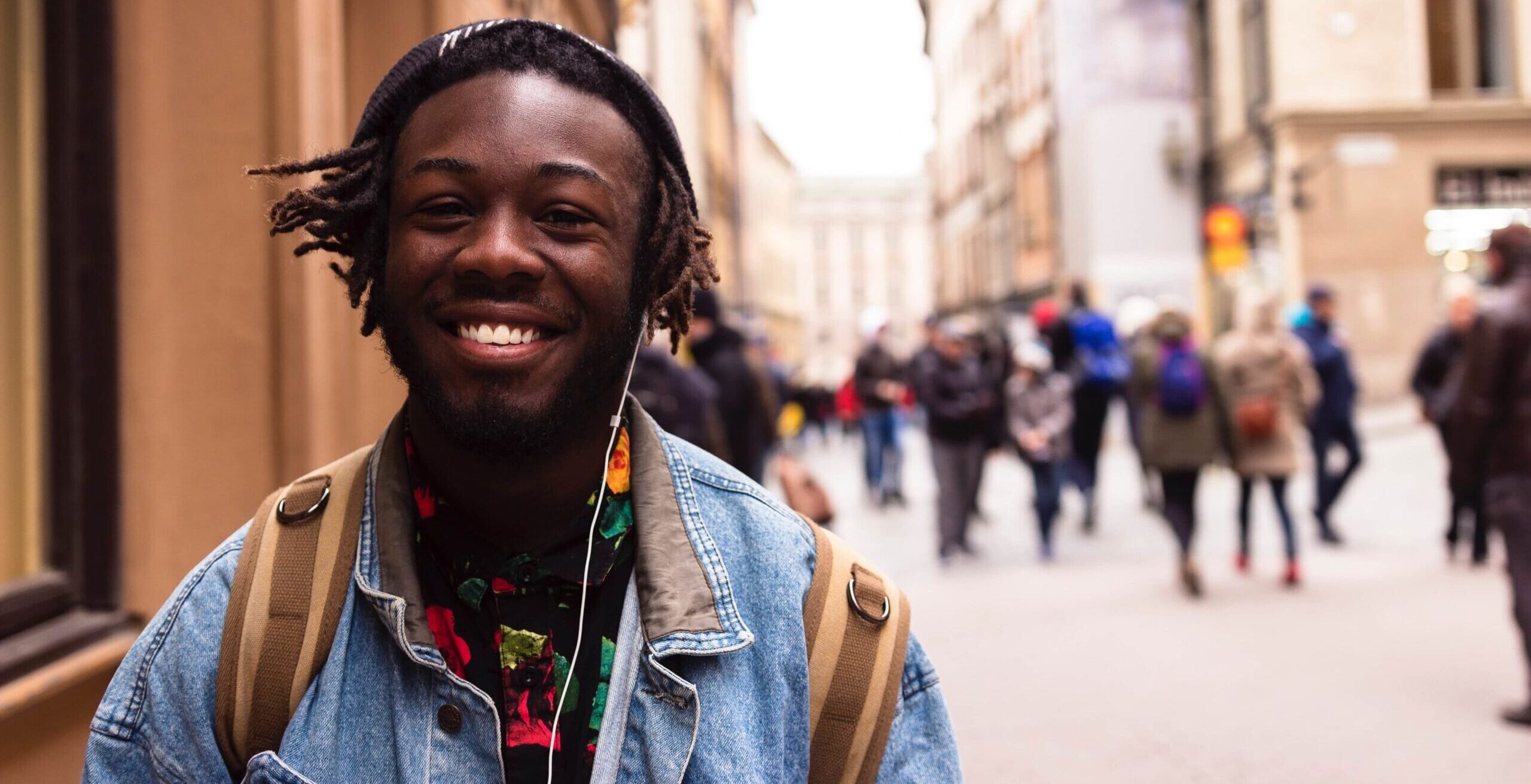 Man smiling walking down sunny street